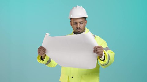Engineering jobs and professions, monitoring the implementation of architectural projects, supervising the progress of construction work, working in the field of structural engineering, a portrait of a Saudi Gulf Arab engineer wearing a vest and safety helmet holding a paper plan and following up on plans at the work site, green background.