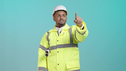 Referring to something, supervising the progress of construction work, following up on architectural projects, working in the field of structural engineering, a close portrait of a Saudi Gulf Arab engineer wearing a vest and safety helmet holding the engineering plan, monitoring the execution at the work site, green background.
