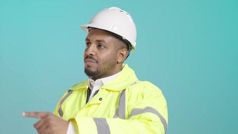 الإشراف على سير أعمال البناء، متابعة المشاريع المعمارية، العمل في مجال الهندسة الإنشائية، بورترية مقرب لمهندس عربي خليجي سعودي يرتدي سترة وخوذة الحماية يحمل المخطط الهندسي  يقوم بمراقبة التنفيذ في موقع العمل، الاشارة الى شيء ما ، خلفية خضراء