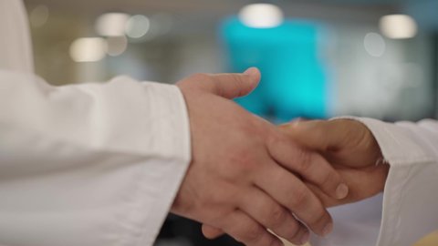 Successful new business deals between businessmen, a team inside a meeting room at the company headquarters, a close-up portrait of two Gulf Arab Omani men shaking hands, the concept of collaborative management