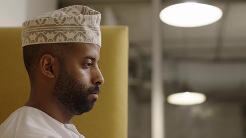 إنجاز مهام الاعمال باحترافية، رجل عربي خليجي عماني يرتدي الدشداشة و الكمة منهمك في العمل, مهن ووظائف ادارية مكتبية, الاندماج و التركيز في المهمة المطلوبة, إدارة شؤون الأعمال و تنظيمها