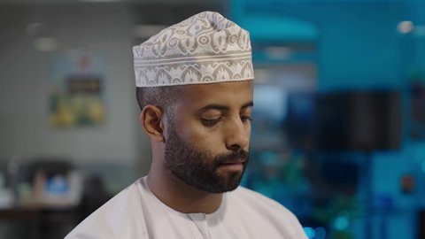 استخدام الهاتف المحمول في العمل، رجل عربي خليجي عماني يرتدي الدشداشة و الكمة يقوم بعرض شاشة الموبايل, الاستفادة من الأجهزة التكنولوجية الحديثة والمتطورة, تصفح مواقع التواصل الاجتماعي عبر الانترنت