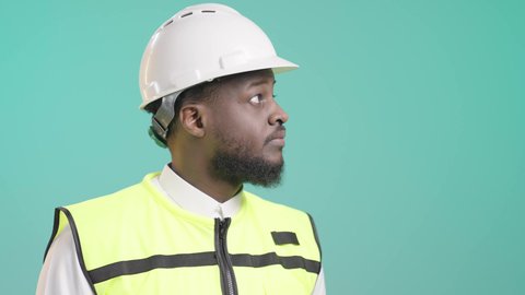 التأكد من سير الأعمال بالشكل المطلوب والصحيح، كتابة آخر المستجدات حول المشروع، بورتريه لمهندس أسمر عربي خليجي سعودي يرتدي الثوب التقليدي و السترة العاكسة و خوذة الحماية يمسك الملف بيده ويكتب فيه بإيماءات التركيز، خلفية زرقاء