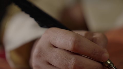 Wearing traditional costume on the national occasion, a close-up of a Saudi Arabian Gulf man wearing a ghutra, golden agal, and bisht holding a pen in his hand, writing on a historical leather manuscript, heritage letters and correspondence for the establishment of the first state in 1727 AD, the day we began, February 22, pride in the authenticity of the Kingdom