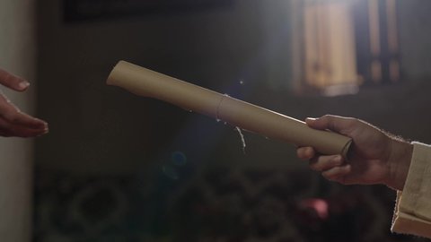 الخطابات والمراسلات التراثية لتأسيس الدولة السعودية الأولى 1727م، يوم بدينا 22 فبراير, ارتداء الزي الشعبي في المناسبة الوطنية، الفخر بأصالة المملكة، تصوير مقرب لرجل عربي خليجي سعودي يرتدي الغترة والعقال الذهبي والبشت يقوم بتسليم مخطوطة جلد تاريخية إلى شخص آخر