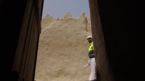 دراسة فن العمارة القديم واساسيات بناء البيوت الطينية، مهندسان عربيان خليجيان سعوديان يرتديان السترة وخوذة الحماية يقفان على اطلال قصر سلوى في البجيري الدرعية، يوم بدينا 1727 م، ذكرى تأسيس الدولة السعودية الأولى 22 فبراير