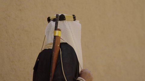 المراقبة والحراسة للدفاع والحفاظ على تاريخ وتراث المملكة، يوم بدينا 22 فبراير، الحرب والقتال بالبنادق لحماية الوطن، تأسيس الدولة السعودية الأولى 1727 م، رجل عربي خليجي سعودي يرتدي الزي الشعبي التقليدي يحمل البندقية في احياء شعبية طينية