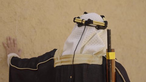 الحراسة والمراقبة للدفاع والحفاظ على تاريخ وتراث المملكة، يوم بدينا 22 فبراير، الحرب والقتال بالبنادق لحماية الوطن، تأسيس الدولة السعودية الأولى 1727 م، رجل عربي خليجي سعودي يرتدي الزي الشعبي التقليدي يحمل البندقية في احياء شعبية طينية