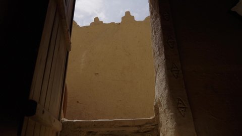 The concept of surveillance and guarding, defense and preservation of the history and heritage of the Kingdom, the day we began on February 22, war and fighting with guns to protect the homeland, the establishment of the first Saudi state in 1727 AD, a Saudi Gulf Arab man wearing traditional folk costume carrying a gun in a mud-brick neighborhood