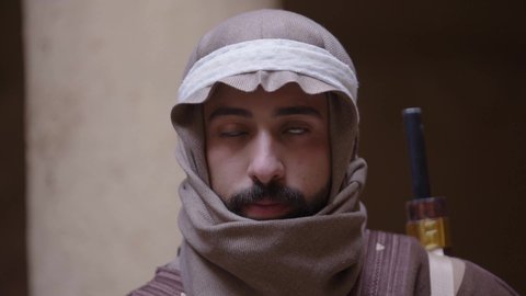 الحرب والقتال بالبنادق لحماية الوطن، تأسيس الدولة السعودية الأولى 1727 م، رجل عربي خليجي سعودي يرتدي الزي الشعبي التقليدي يحمل البندقية في احياء شعبية طينية، مفهوم المراقبة والحراسة، الحفاظ والدفاع على تاريخ وتراث المملكة، يوم بدينا 22 فبراير