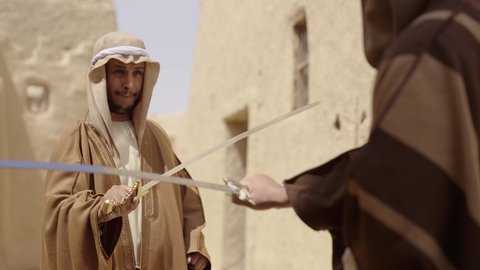 أدوات الحرب القديمة، المبارزة بالسيف للحماية وتأسيس الدولة السعودية الأولى 1727 م، رجلان عربيان خليجيان سعوديان يرتديان الزي الشعبي يتبارزان بالسيوف في بيت طيني، يوم بدينا 22 فبراير، مفهوم الحرب والدفاع عن الوطن، الحفاظ على تاريخ وتراث المملكة