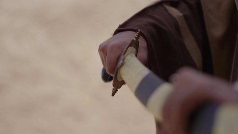 أدوات الحرب القديمة، المبارزة بالسيف للحماية وتأسيس الدولة السعودية الأولى 1727 م، رجلان عربيان خليجيان سعوديان يرتديان الزي الشعبي يتبارزان بالسيوف في بيت طيني، يوم بدينا 22 فبراير، مفهوم الحرب والدفاع عن الوطن، الحفاظ على تاريخ وتراث المملكة