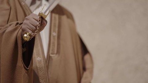 Ancient war tools, sword fighting for protection and the establishment of the first Saudi state in 1727 AD, two Saudi Gulf Arab men wearing traditional costumes dueling with swords in a mud house, the day of our beginning, February 22, the concept of war and defending the homeland, preserving the history and heritage of the Kingdom