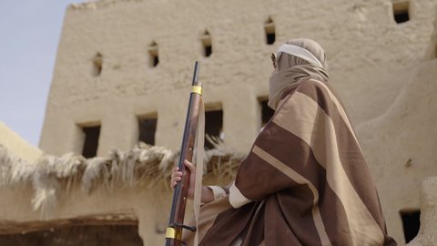 استخدام السلاح للحفاظ على وممتلكات المملكة، رجل عربي خليجي سعودي يرتدي زي شعبي تقليدي يمسك بيده البندقيه، يوم بدينا  1727 م، ذكرى تأسيس الدولة السعودية الأولى 22 فبراير، الاستعداد والتجهز للدفاع وحماية الوطن