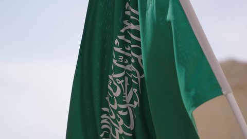 علم المملكة العربية السعودية المرفرف في مكان تاريخي قديم، الاحتفال بذكرى اليوم الوطني السعودي 23 سبتمبر، يوم العلم 11 مارس، راية التوحيد والإسلام في منزل طيني قديم، احتفالات ومناسبات وطنية، مفهوم حب الوطن والانتماء إليه