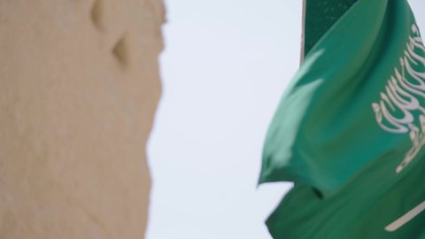 علم المملكة العربية السعودية المرفرف في مكان تاريخي قديم، الاحتفال بذكرى اليوم الوطني السعودي 23 سبتمبر، يوم العلم 11 مارس، راية التوحيد والإسلام في منزل طيني قديم، احتفالات ومناسبات وطنية، مفهوم حب الوطن والانتماء إليه