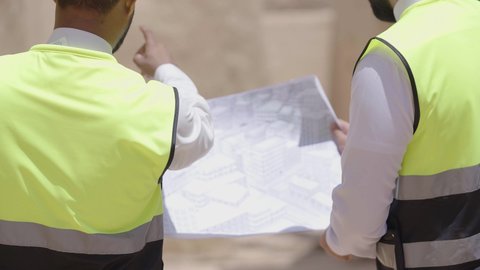 تبادل الاحاديث حول اكتشاف فن العمارة القديم، مهندسان عربيان خليجيان سعوديان يرتديان السترة وخوذة الحماية ينظران الى اساسيات بناء البيوت الطينية، يوم بدينا 1727 م، ذكرى تأسيس الدولة السعودية الأولى 22 فبراير