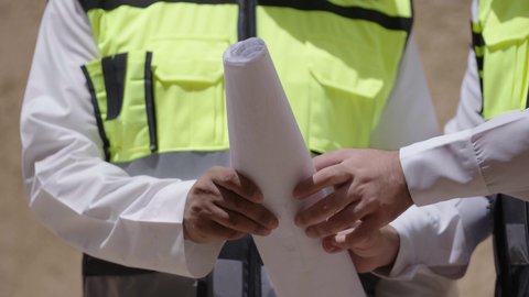 مهندسان عربيان خليجيان سعوديان يرتديان السترة وخوذة الحماية ينظران الى اساسيات بناء البيوت الطينية، يوم بدينا 1727 م، ذكرى تأسيس الدولة السعودية الأولى 22 فبراير، تبادل الاحاديث حول اكتشاف فن العمارة القديم