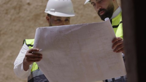 يوم بدينا 1727 م، ذكرى تأسيس الدولة السعودية الأولى 22 فبراير، تبادل الاحاديث حول اكتشاف فن العمارة القديم، مهندسان عربيان خليجيان سعوديان يرتديان السترة وخوذة الحماية ينظران الى اساسيات بناء البيوت الطينية