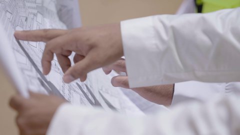 The Day We Began 1727 AD, the anniversary of the founding of the first Saudi state, February 22, exchanging conversations about discovering ancient architecture, two Saudi Gulf Arab engineers wearing jackets and protective helmets looking at the basics of building mud houses