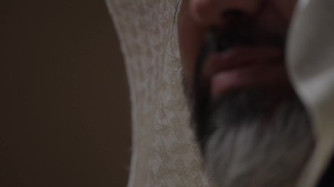 مفهوم حب الوطن والانتماء اليه، قرية تاريخية قديمة، ارتداء الزي الشعبي  التقليدي في عيد ومناسبة وطنية، إحياء ذكرى تأسيس الدولة السعودية الأولى 1727 م, يوم بدينا 22 فبراير, رجل عربي خليجي سعودي يرتدي البشت والغترة والعقال الذهبي العريض يقف أمام منزل طيني قديم