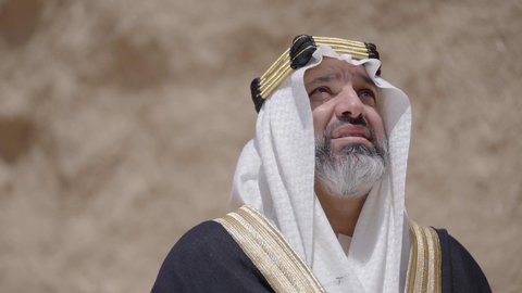 التجول في الاماكن التاريخية القديمة، ذكرى تأسيس الدولة السعودية الأولى 1727 م, يوم بدينا 22 فبراير, رجل عربي خليجي سعودي يرتدي البشت والغترة والعقال الذهبي العريض يقف في مكان أثري قديم، مفهوم حب الوطن والانتماء اليه، ارتداء الزي الشعبي  التقليدي في المناسبة الوطنية