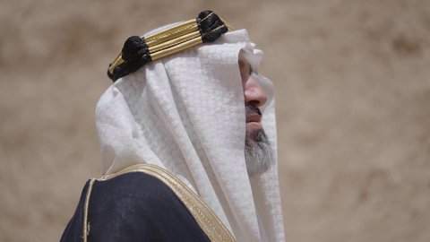 التجول في الاماكن التاريخية القديمة، ذكرى تأسيس الدولة السعودية الأولى 1727 م, يوم بدينا 22 فبراير, رجل عربي خليجي سعودي يرتدي البشت والغترة والعقال الذهبي العريض يقف في مكان أثري قديم، مفهوم حب الوطن والانتماء اليه، ارتداء الزي الشعبي  التقليدي في المناسبة الوطنية