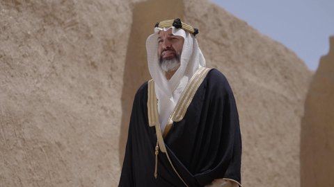 حب الوطن والانتماء اليه، التجول في الاماكن التاريخية القديمة، ذكرى تأسيس الدولة السعودية الأولى 1727 م, يوم بدينا 22 فبراير, رجل عربي خليجي سعودي يرتدي البشت والغترة والعقال الذهبي العريض يقف في مكان أثري قديم، ارتداء الزي الشعبي  التقليدي في المناسبة الوطنية