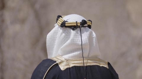 ارتداء الزي الشعبي لإحياء عيد ومناسبة وطنية، قرية تاريخية قديمة، إحياء ذكرى تأسيس الدولة السعودية الأولى 1727 م, يوم بدينا 22 فبراير, رجل عربي خليجي سعودي يرتدي البشت والغترة والعقال الذهبي العريض يتجول في الأحياء القديمة، مفهوم حب الوطن والانتماء اليه