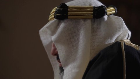 The day we started, February 22nd, a Saudi Arabian Gulf man wearing a bisht, ghutra, and a wide golden agal standing in an old mud house, the concept of patriotism and belonging to the homeland, an old historical village, wearing traditional folk costume on a national holiday and occasion, commemorating the founding of the first Saudi state in 1727 AD