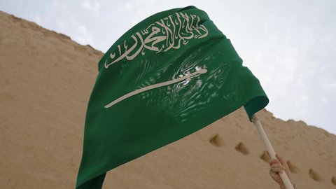 علم المملكة العربية السعودية المرفرف في مكان تاريخي قديم، الاحتفال بذكرى اليوم الوطني السعودي 23 سبتمبر، يوم العلم 11 مارس، راية التوحيد والإسلام في منزل طيني قديم، احتفالات ومناسبات وطنية، مفهوم حب الوطن والانتماء إليه