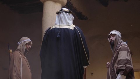 الحوار والتخطيط للحرب، يوم بدينا 22 فبراير، القتال بالبنادق للحماية وتأسيس الدولة السعودية الأولى 1727م، مجموعة رجال عرب خليجيين سعوديين ملثمين يرتدون الزي الشعبي التقليدي يحملون البندقيات، الحراسة والمراقبة للدفاع عن الوطن