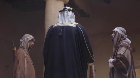 Dialogue and planning for war, the day we began, February 22, fighting with rifles to protect and establish the first Saudi state in 1727 AD, a group of masked Saudi Gulf Arab men wearing traditional folk costumes carrying rifles, guarding and monitoring to defend the homeland