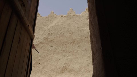 الاحتفال باليوم الوطني 23 سبتمبر, ذكرى يوم التأسيس 22 فبراير, سيدة عربية خليجية سعودية ترتدي العباءة السوداء والبرقع تمسك بيدها العلم وتتجول في الاحياء القديمة, يوم العلم السعودي 11 مارس, التفاخر بالإنتماء للوطن, ارتداء الأزياء الشعبية التقليدية في المناسبة الوطنية