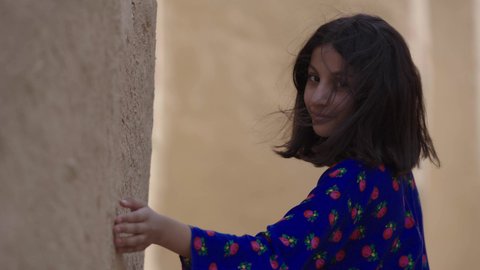 المحافظة على التراث السعودي، تربيه الأبناء على حب الوطن، يوم بدينا 1727 م، ذكرى تأسيس الدولة السعودية الاولى 22 فبراير، تصوير مقرب لفتاة عربيه خليجية سعودية مبتسمة ترتدي الزي التقليدي الشعبي تتجول في منزل طيني، الاحتفال بالمناسبات والأعياد الوطنية بإيماءات السعادة