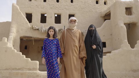 ذكرى تأسيس الدولة السعودية الاولى 22 فبراير، عائلة عربيه خليجية سعودية ترتدي الزي الشعبي التقليدي في الأعياد والمناسبات الوطنية يقفون في إحدى البيوت التراثية المبنية من الطين، تعابير وإيماءات الاعتزاز والفخر والسعادة، يوم بدينا 1727 م
