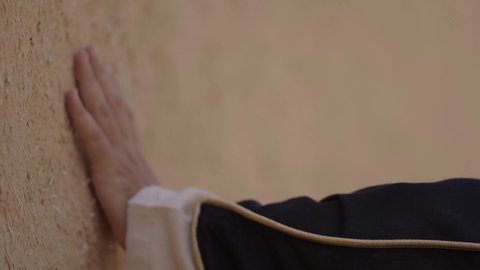 احياء ذكرى تأسيس الدولة السعودية الاولى 22 فبراير، تصوير مقرب ليد رجل عربي خليجي سعودي رتدي الزي الشعبي يقوم بلمس جدار من الطين، البيوت الطينية التراثية، يوم بدينا 1727 م