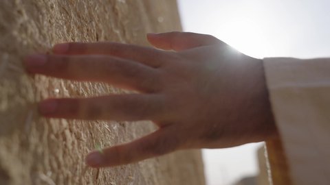 البيوت الطينية التراثية، يوم بدينا 1727 م، احياء ذكرى تأسيس الدولة السعودية الاولى 22 فبراير، تصوير مقرب ليد رجل عربي خليجي سعودي رتدي الزي الشعبي يقوم بلمس جدار من الطين