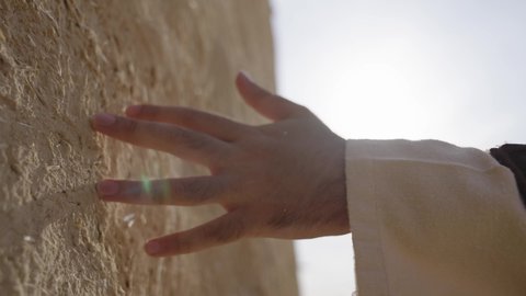 احياء ذكرى تأسيس الدولة السعودية الاولى 22 فبراير، تصوير مقرب ليد رجل عربي خليجي سعودي رتدي الزي الشعبي يقوم بلمس جدار من الطين، البيوت الطينية التراثية، يوم بدينا 1727 م