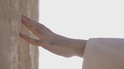 احياء ذكرى تأسيس الدولة السعودية الاولى 22 فبراير، تصوير مقرب ليد رجل عربي خليجي سعودي رتدي الزي الشعبي يقوم بلمس جدار من الطين، البيوت الطينية التراثية، يوم بدينا 1727 م