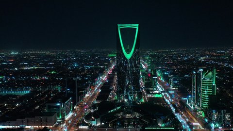 The economic and cultural renaissance in the Kingdom of Saudi Arabia, urban development and growth in cities and neighborhoods, aerial photography of roads and streets in, the Kingdom Tower in Riyadh at night, towers and skyscrapers built in a modern style, a famous tourist attraction in the capital