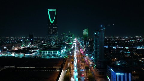 The economic and cultural renaissance in the Kingdom of Saudi Arabia, urban development and growth in cities and neighborhoods, aerial photography of roads and streets in, the Kingdom Tower in Riyadh at night, towers and skyscrapers built in a modern style, a famous tourist attraction in the capital