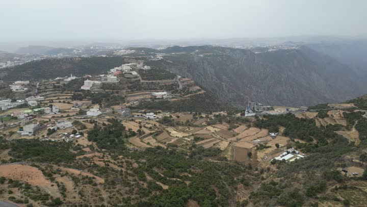 سلاسل جبال أبها والنماص الصخرية، التضاريس الحجرية الوعرة، تصوير جوي للبيئة الجبلية في منطقة عسير، جذب واستقطاب السياح من كافة انحاء العالم، الأماكن والمعالم السياحية الطبيعية المشهورة، الأشجار والنباتات على سفوح الجبل