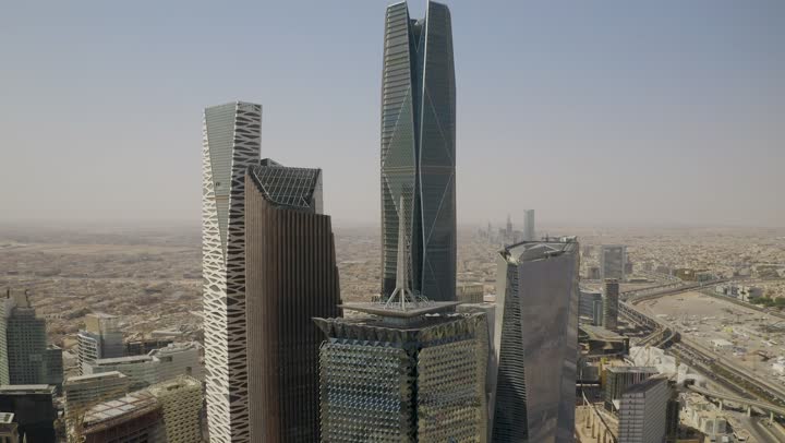 Famous landmarks of commerce and economy, King Abdullah Financial District (KAFD), economic and urban renaissance, aerial drone photography of Riyadh's skyline during the day, modern and advanced towers and skyscrapers