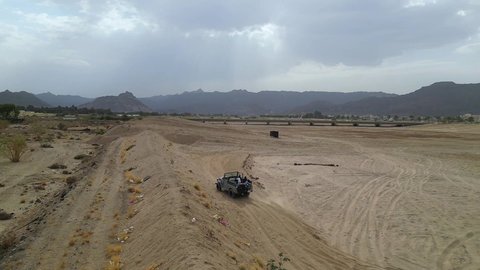 An exciting safari adventure on the sand dunes and hills, a fun recreational activity, safari trips in the deserts of the Kingdom of Saudi Arabia, spending a special trip in the desert environment, driving an old white jeep in the Najran Valley, (drifting) in the middle of the desert