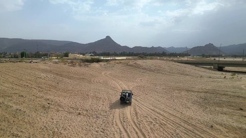 An exciting safari adventure on the sand dunes and hills, a fun recreational activity, safari trips in the deserts of the Kingdom of Saudi Arabia, spending a special trip in the desert environment, driving an old white jeep in the Najran Valley, (drifting) in the middle of the desert