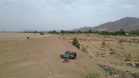 An exciting safari adventure on the sand dunes and hills, a fun recreational activity, safari trips in the deserts of the Kingdom of Saudi Arabia, spending a special trip in the desert environment, driving an old white jeep in the Najran Valley, (drifting) in the middle of the desert