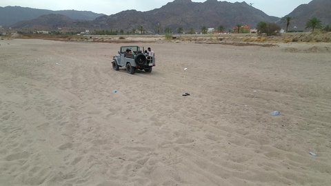 A fun recreational activity, safari trips in the deserts of the Kingdom of Saudi Arabia, spending a special trip in the desert environment, driving an old white jeep in the Najran Valley, (dune bashing) in the middle of the desert, an exciting safari adventure on the sand dunes and hills.