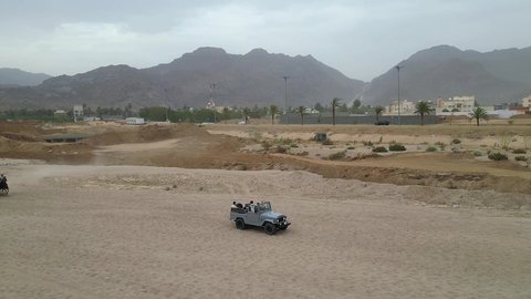 A fun recreational activity, safari trips in the deserts of the Kingdom of Saudi Arabia, spending a special trip in the desert environment, driving an old white jeep in the Najran Valley, (dune bashing) in the middle of the desert, an exciting safari adventure on the sand dunes and hills.