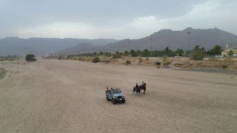 The hobby of riding purebred Arabian horses, an exciting safari adventure on the sand dunes and hills, a fun recreational activity, safari trips in the deserts of the Kingdom of Saudi Arabia, spending a special trip in the desert environment, driving an old white jeep in the Najran Valley, (drifting) in the middle of the desert